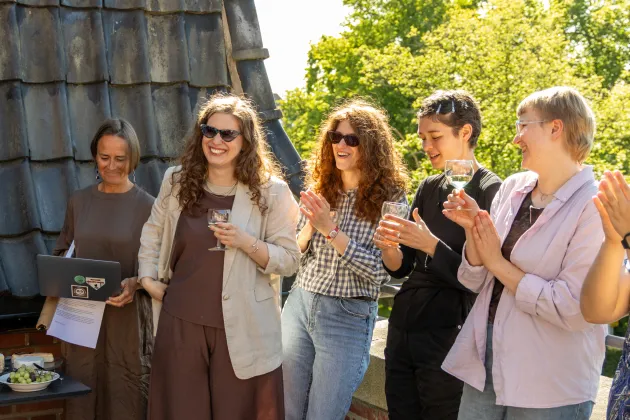 Five persons standing in the sun.