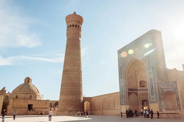 En minaret bredvid ett valv i solsken.